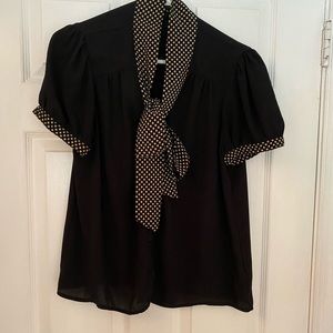 Black button up blouse with tan polka dot tie.
